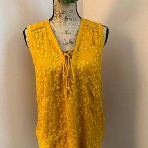 Sleeveless embroidered blouse with lace up front.